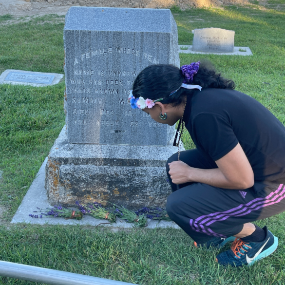 Omni, Director of CARE places lavender bundles on the gravesite of Sammy Williams 