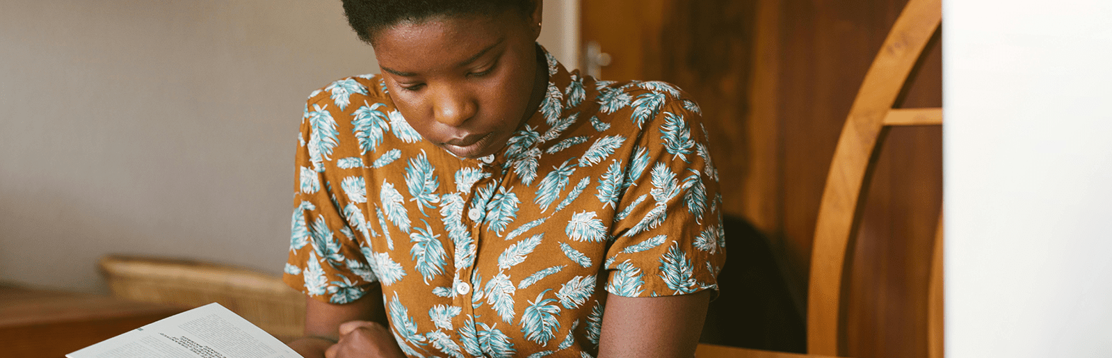 A Black student with short hair studies at a table.